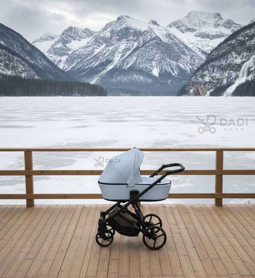 Wózek dziecięcy Kunert na pomoście nad zamarzniętym jeziorem z ośnieżonymi górami – idealny wózek na zimowe spacery.